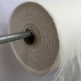 A roll of white plastic wrap on a metal dispenser, showcasing its smooth surface and core, indicating its use for food preservation.