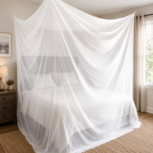 A bed draped with a sheer white mosquito net in a cozy bedroom, providing protection and creating a serene atmosphere.
