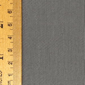 Gray fabric background with a wooden ruler measuring up to 6 inches, showcasing precise dimensions for textiles or crafts.